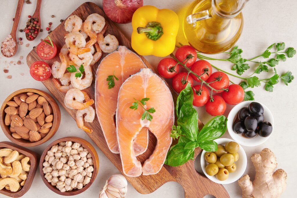 Variedad de alimentos ricos en grasas saludables como aguacates, nueces, aceite de oliva y pescado.